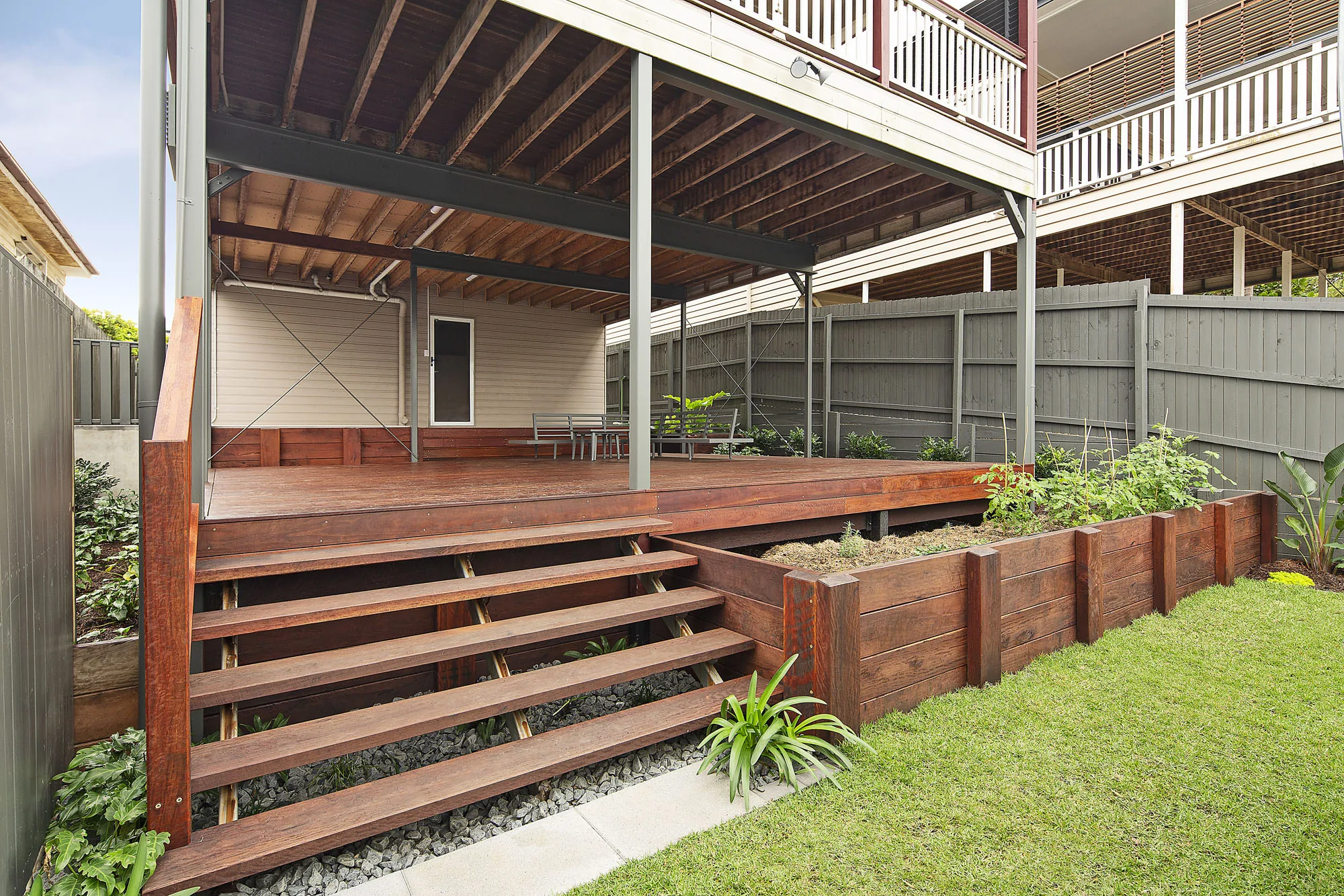 Timber steps and deck leading down through a casual native garden bed