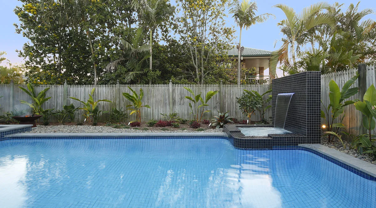 Pool with a corten fire bowl and sunken spa bay under warm afternoon light